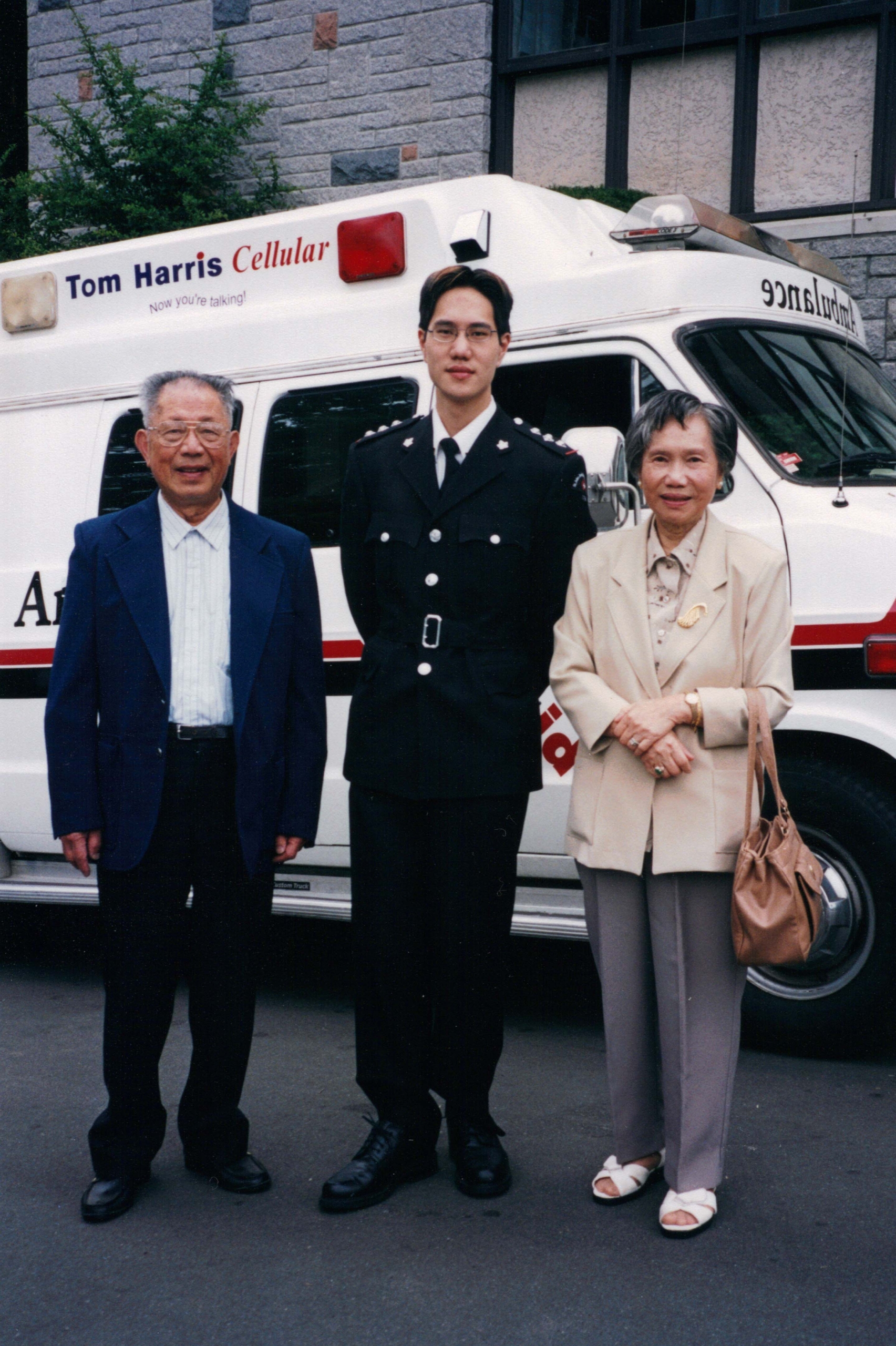 Brian Lee, Clinical Nurse Educator with his parents in front of a St. John Ambulance