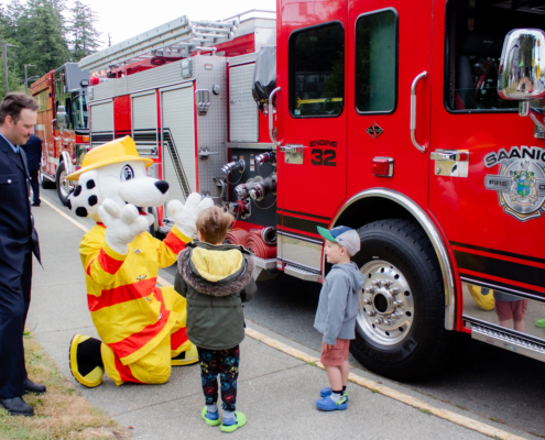 Sparky the Fire Dog shows a firetruck to former NICU pediatric patients outside of Victoria General Hospital