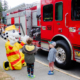 Sparky the Fire Dog shows a firetruck to former NICU pediatric patients outside of Victoria General Hospital