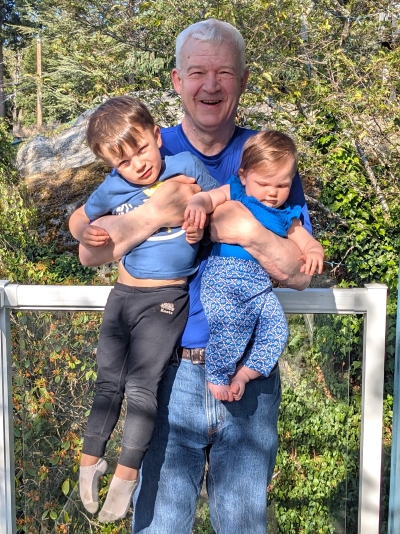 Doug Wrean, robotics patient, picking up his two grandchildren.