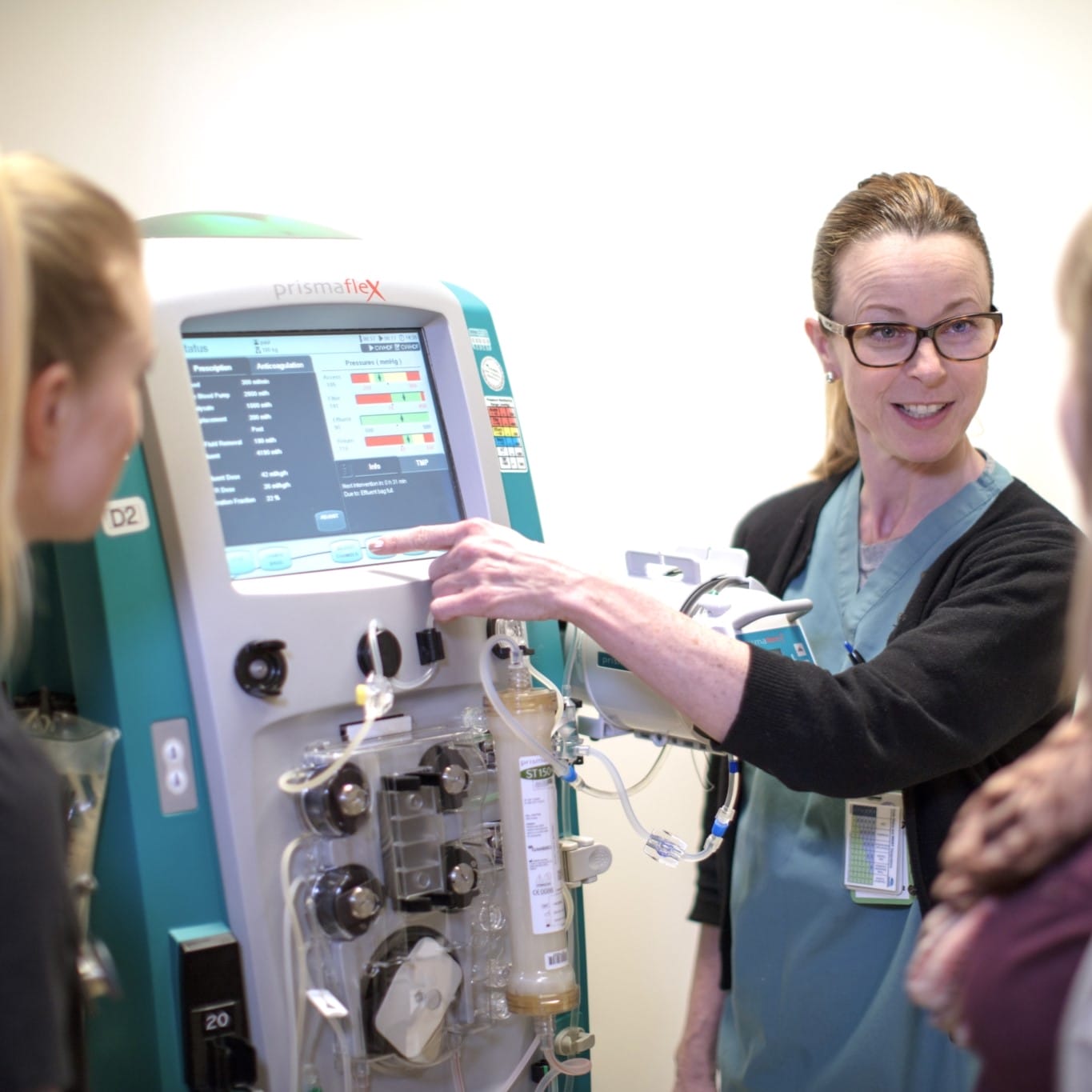 Nurse instructing students on how to use a piece of equipment